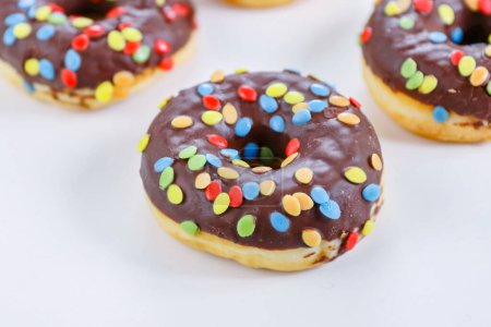 Photo for Set of Brown chocolate donut decorated with smarties isolated on white background side view. Fried dough confection, dessert food, sweet snack with chocolate glazing and candies. Selective focus - Royalty Free Image