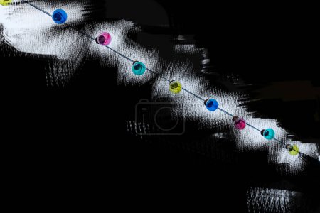 Foto de Bombillas de luz de guirnalda de Navidad aisladas sobre fondo abstracto de graffiti con salpicaduras salvajes de blanco negro amarillo. Minimalista conceptual simple idea de diseño de arte gráfico para carteles, anuncios. Copiar espacio - Imagen libre de derechos