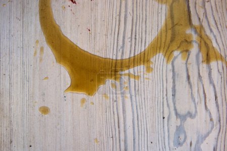 Coffee stains on white wooden table. Wood texture background. Big dark brown dramatic Splatter, fleck, splash, spot, drops of black coffee. Pattern, wallpaper. Top view.  Closeup. Copy space.
