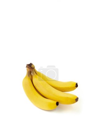 Drei gelbe Bananen sitzen auf weißem Hintergrund. Die Bananen sind reif und verzehrfertig. Konzept von Frische und Überfluss, da die Bananen reichlich und reif sind