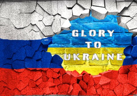 A flag is torn apart and the words Glory to Ukraine are written on the wall behind it