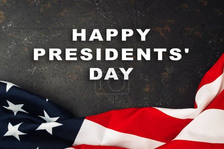 Photo for A red and white American flag with the words Happy Presidents' Day written below it. The flag is draped over a dark background, creating a sense of patriotism and celebration - Royalty Free Image