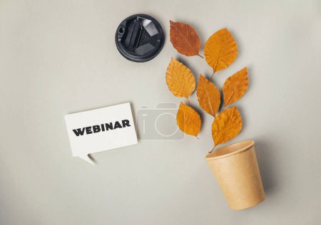 Un signo blanco con la palabra "webinar" escrita en él se coloca junto a una planta en maceta con hojas