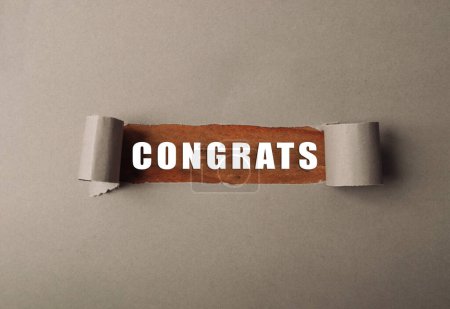 Ein zerrissenes Blatt Papier, auf dem das Wort "Glückwunsch" steht. Das Image hat einen Sinn für Feier und Leistung