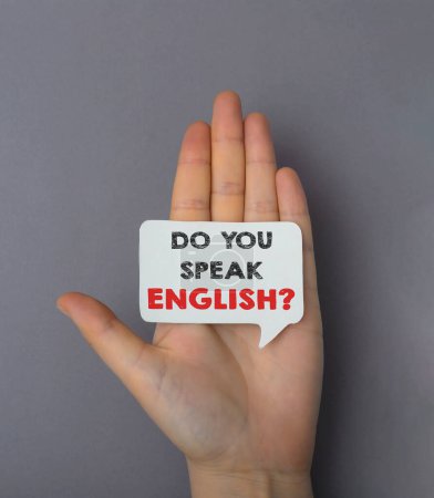 Eine Hand hält ein Schild mit der Aufschrift Do you speak English. Konzept der Neugier und des Interesses am Erlernen einer neuen Sprache