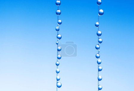 kleine blaue Wassertröpfchen hängen an der Angelschnur, Makroaufnahme