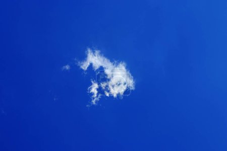 eine einzige kleine flauschige weiße Wolke am blauen Himmel