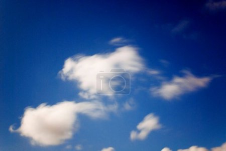 white cumulus spring clouds in blue sky