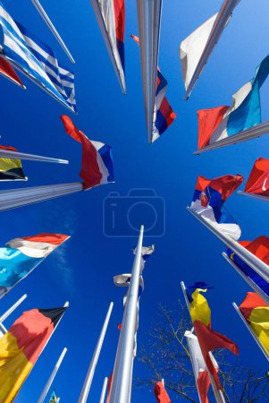 bastones con banderas nacionales de los países europeos en el cielo azul, frente a la Organización Europea de Patentes en Munich, Baviera, Alemania