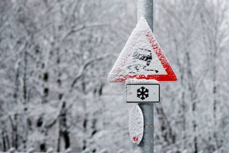 warning sign danger of skidding, snow covered in winter, Munich, Bavaria, Germany
