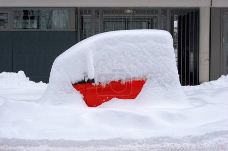 ein roter Smart, ein winziges Auto, geparkt und komplett mit Schnee bedeckt, Winter, München, Bayern, Deutschland
