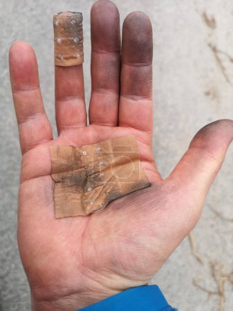 main sale avec des plâtres de protection d'un travailleur de l'industrie après avoir terminé le travail