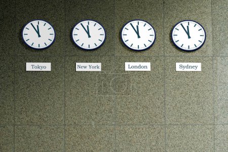 vier Uhren an einer Wand, die die Weltzeit von Tokio, London, New York und Sydney anzeigen, aber alle stehen auf fünf vor zwölf, was darauf hindeutet, dass es höchste Zeit ist