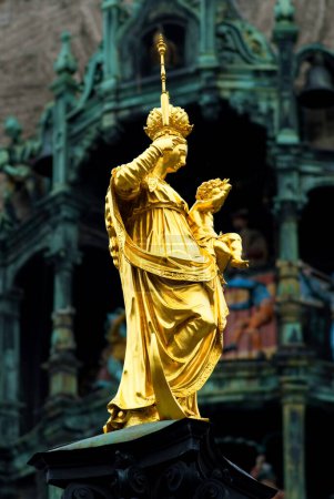 Estatua de María María con Jesús frente al Glockenspiel del Nuevo Ayuntamiento Marienplatz, Munich, Baviera, Alemania