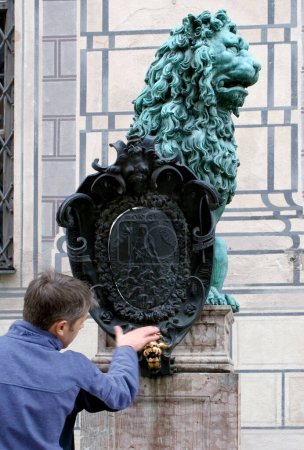 rubbing the nose of the lucky lion, Munich, Bavaria, Germany