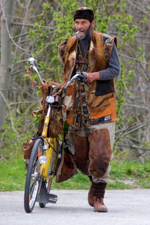 Photo for Munich, Bavaria, Germany, April 18th 2007, individualist with homemade clothes pushes his bike and smokes to pose for the photographer - Royalty Free Image