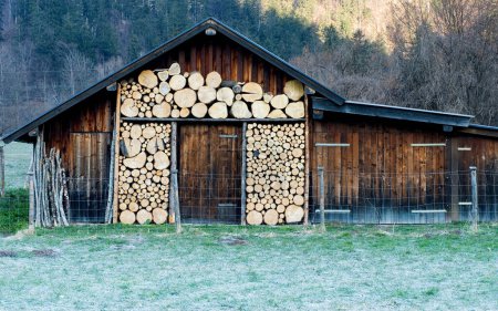 Photo for Garmisch-Partenkirchen, Bavaria, Germany, February 20th 2008, a wooden hut with picturesquely stacked wood - Royalty Free Image