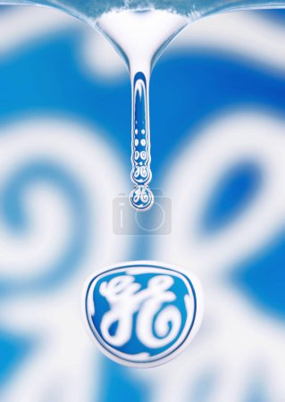 Téléchargez les photos : Macro prise de vue d'une goutte d'eau qui goutte, le logo General Electrics se reflète dans la goutte - en image libre de droit