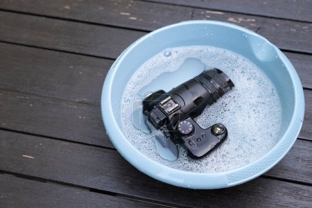 Téléchargez les photos : Vieil appareil photo numérique de 2006 avec 6 MP est nettoyé pour le plaisir dans l'eau - en image libre de droit