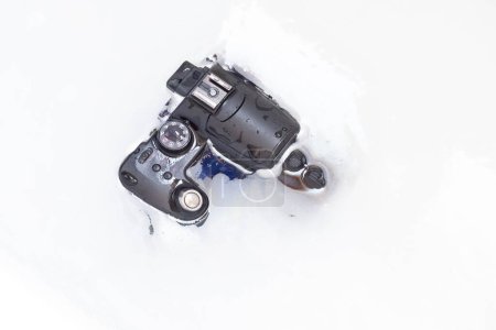 Téléchargez les photos : Vieil appareil photo numérique de 2006 avec 6 MP est nettoyé pour le plaisir dans l'eau - en image libre de droit