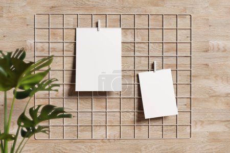 Photo for Empty white posters on moodboard and plant on wooden background - Royalty Free Image