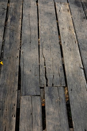 Close up of old abandoned rickety foot bridge. Old wood texture background coming from natural tree. The wooden panel has a beautiful dark pattern.
