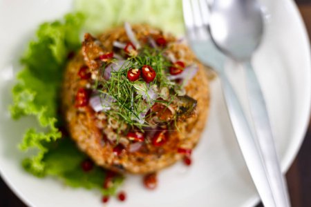 Thailändisches Essen, Gebratener Jasminreis mit Makrele in Tomatensauce, garniert mit rotem Chili, roten Zwiebeln, Salat und Kaffir-Limettenblättern.