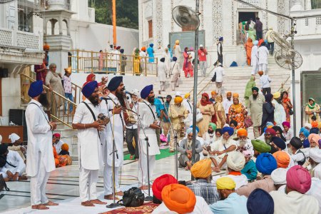 Téléchargez les photos : Amritsar, Punjab, Inde - Diwali 2019 - 28 octobre 2019 - groupe de musiciens au temple d'or, se produisant sur des instruments traditionnels sikh devant la foule assise. - en image libre de droit