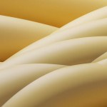 A detailed close-up showcases the intricate texture and pattern of cream-colored twisted fibers. The warm, golden background enhances the visual depth and elegance of the twisted strands, suggesting a