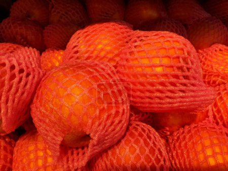 Haufen Fuji-Apfel in EPE-Schaumstoffnetz, um Früchte vor Beschädigungen im Supermarktregal zu schützen. Recyclingkonzept.