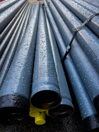 Close up shot of a pile of pipes laying after rain
