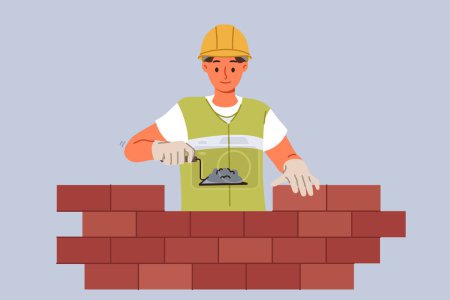 Man bricklayer builder builds brick wall using trowel with concrete mixture to secure blocks. Guy bricklayer in yellow vest and hardhat works in architectural company performing contract work