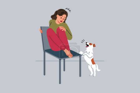 Teenage girl is afraid of dog and climbs onto chair to hide from puppy and needs treatment for cynophobia. Kid feels panic attack at sight of pets due to cynophobia or possibility of allergic reaction