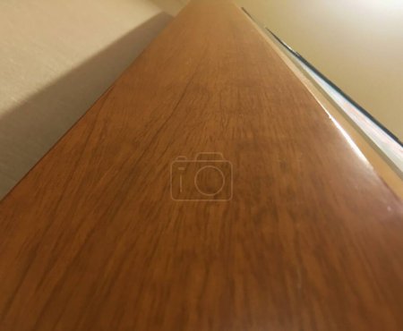 Foto de Marco de madera con superficie marrón. El marco está en una habitación con paredes blancas. La tabla es el foco principal de la imagen. - Imagen libre de derechos