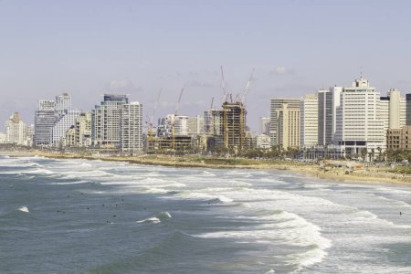 Panoramablick auf Tel Avivs Küste mit Skyline der Stadt und Wellen, die auf den Strand krachen