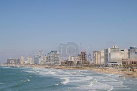 Panoramablick auf Tel Avivs Küste mit Skyline der Stadt und Wellen, die auf den Strand krachen