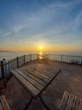 Ein friedlicher Abend: Ruhige Aussicht auf den Sonnenuntergang von einem hölzernen Pier