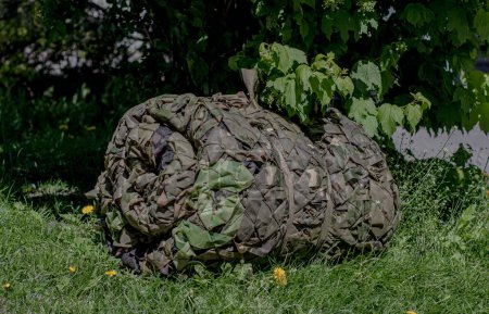 volunteering, rolled-up camouflage netting for the military, war in Ukraine
