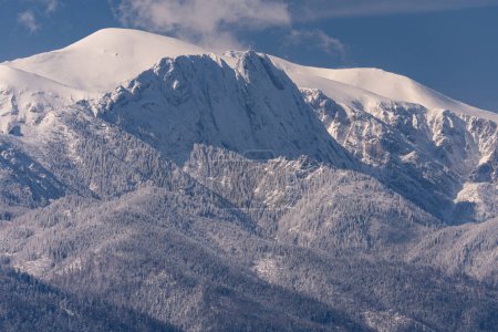 Foto de Montaña Giewont y picos de Tatra, Polonia invierno paisaje cubierto de nieve. Cielo azul sin nubes. Vista desde el pueblo de Gliczarow cerca de la ciudad de Zakopane. - Imagen libre de derechos