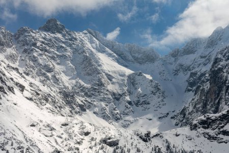 Mira de cerca las montañas polacas de los Altos Tatras sobre la vaina Czarny Staw Rysami. En el bacground Rysy, Nizne Rysy, y Wolowa Turnia picos cubiertos de nieve con cielo azul en el día soleado y algunas nubes