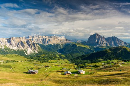 Vista desde la montaña Seceda en Val Gardena en los Dolomitas italianos en el soleado día de verano con hierba verde y cielo azul con nubes.