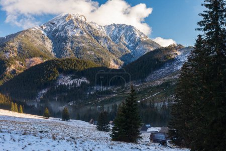 Polana Chocholowska an einem sonnigen Wintertag in der westlichen Tatra, Polen. Das Tal und alte Holzhütten mit Schnee bedeckt