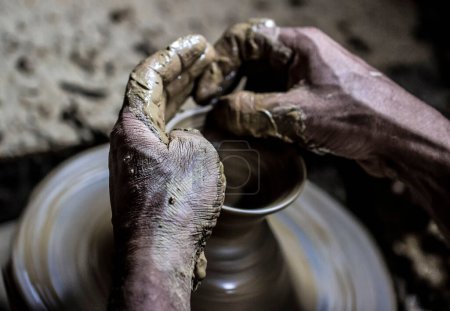 Hand of a pottery worker preparing an earthen cookware