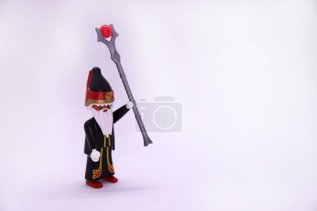 Photo for Playmobil doll of sorcerer with magic staff on white background and with copy space. Collectible toy for children. Wizard with cape and magic wand. - Royalty Free Image
