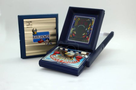 Téléchargez les photos : Jeu vidéo de flipper électronique de marque Casio des années 80 et console manuelle de marque Nintendo du jeu appelé Rain Shower. Jeux pour les enfants joueurs avec fond blanc isolé. Flipper miracle. - en image libre de droit