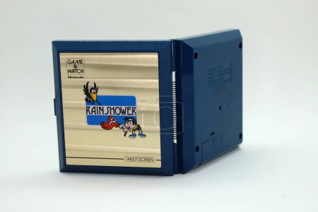 Téléchargez les photos : Console portable rétro de la marque Nintendo des années 80 du jeu appelé Rain Shower. Jeu vidéo portable multi-écrans. Jeu et regarder. Jeu pour empêcher les chemises accrochées à la corde de se mouiller. - en image libre de droit