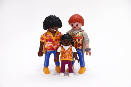Photo for Playmobil dolls. Toys, figures. White background. Isolated. Male couple with their daughter. Friends. Gays. Same gender multicultural couple. LGBT or LGBT community. Happy people. Love. - Royalty Free Image