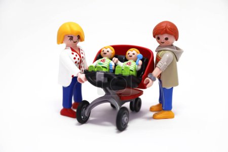Photo for Mother, father and sons. Mom, dad and twins babies in their double stroller. Family. Love. Playmobil dolls. Toys, figures. Happy family portrait. White background. Isolated. Man, woman and childrens. - Royalty Free Image