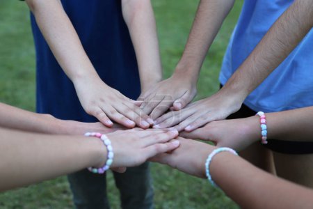 Group of friends with their hands joined. Teamwork. Friendship. Family. Union. Child's play. Preteen friends. friendship pact. group game. Stack of hands showing unity and teamwork.