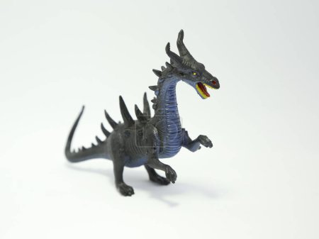 Horned dragon throws fire. Evil monster. Angry and bad dragon. Toy for children. Plastic toy.